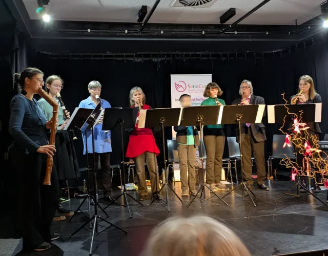Gruppe von Musikern mit Blockflöte auf Bühne.